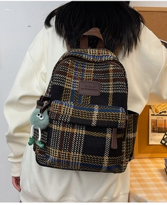 Sac à dos rétro en tweed à carreaux avec logo en cuir et pompon vert sur modèle