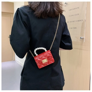 Mini sac matelassé rouge brillant avec anse en perles et chaîne dorée sur mannequin