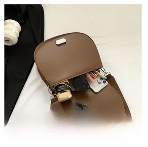 Vue intérieure pratique du sac selle en cuir PU marron montrant sa grande capacité