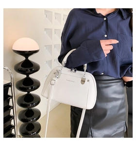Détail du sac à bandoulière en cuir PU blanc avec boucles argentées et logo mode