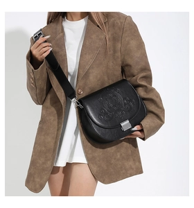 Détail du sac bandoulière noir en PU avec motifs étoiles en relief et fermoir métallique