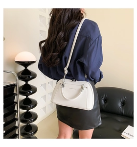 Détail d'un sac bandoulière blanc en cuir PU avec texte imprimé et double fermeture éclair