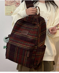 Détail du sac à dos vintage en nylon à carreaux avec étiquette en cuir marron