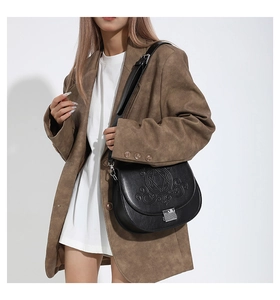Détail du sac besace en cuir PU noir avec motif étoile gravé et fermoir métallique