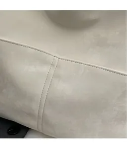 Close-up of beige textured PU leather crossbody bag featuring durable double stitching details