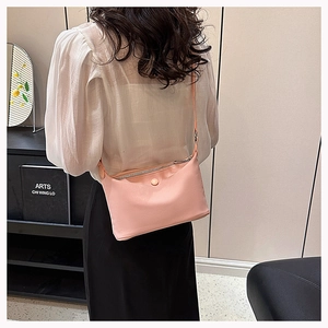 Detail of peach pink canvas camera bag with zipper closure and thin shoulder strap