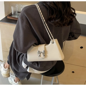 Elegante borsa a tracolla in pelle PU bianco crema con fiocco argento su modella