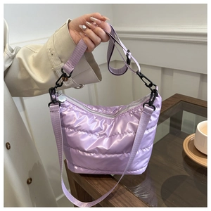 Detail of purple quilted nylon crossbody bag featuring glossy fabric and zipper closure