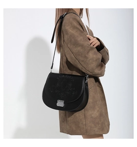 Détail du sac selle noir en PU avec motifs gaufrés et fermoir à poussoir argenté