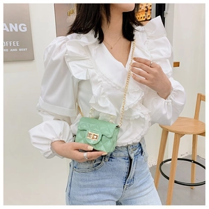 Détail du mini sac bandoulière matelassé vert menthe avec poignée perle et chaîne dorée