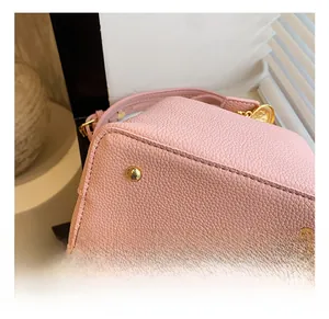 Vue détaillée du sac en cuir grainé rose avec quatre rivets de protection en métal doré