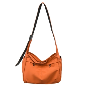 Vibrant orange nylon crossbody bag with adjustable wide strap and functional side pockets