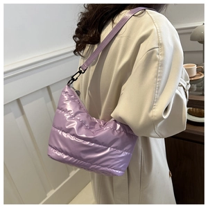 Detail of purple quilted puffer shoulder bag with glossy metallic finish fabric