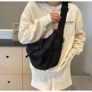 Detail of high-density nylon crescent bag with adjustable wide strap on casual outfit