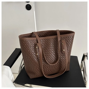 Sac fourre-tout minimaliste en cuir PU tressé marron foncé avec rivets dorés sur chaise