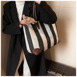 Vista dettagliata di una grande borsa tote a righe bianche e nere con dettagli in cuoio