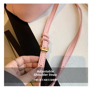Détail du sac à bandoulière rose en cuir avec sangle réglable et boucle en métal doré
