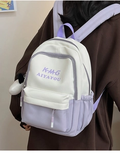 Detail of white and lavender backpack with plush charm and side storage pockets