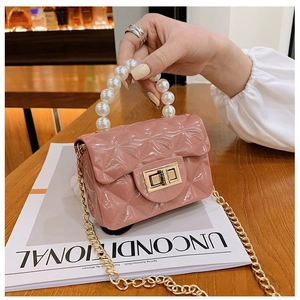 Détail du sac matelassé rose avec poignée en perles et bandoulière en métal doré
