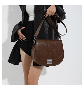 Détail d'un sac selle en cuir PU marron avec motif étoile hexagonale et boucle argent