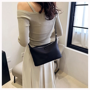 Minimalist black leather underarm bag shown on model for a trendy daily style