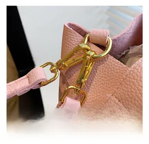 Détail de la bandoulière en cuir rose avec crochet en métal doré poli brillant
