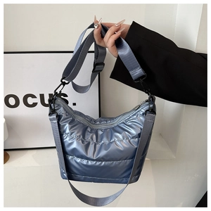 Close-up of blue-grey quilted nylon shoulder bag with glossy metallic finish and wide strap