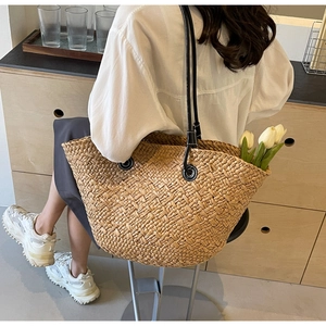 Détail du sac fourre-tout en paille tissé main avec anses en cuir noir et tulipes