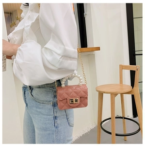 Vue détaillée du mini sac rose matelassé avec poignée en perles et chaîne dorée
