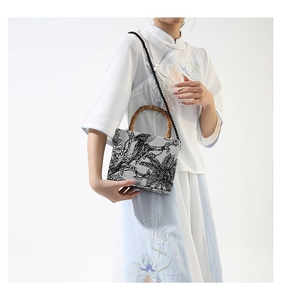Close-up of vintage canvas bag with ink painting patterns and bamboo handles