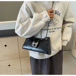 Dettaglio mini borsa a tracolla nera in PU con fibbia a fiocco argento e cinturino a catena