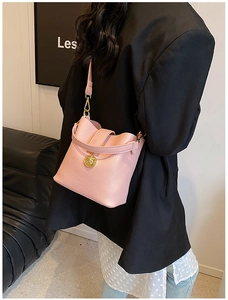 Vue arrière d'un sac seau en cuir grainé rose avec ornement tête de lion dorée sur modèle