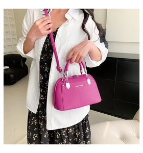 Vue détaillée du cuir grainé magenta et de la fermeture éclair métallique sur le sac à main