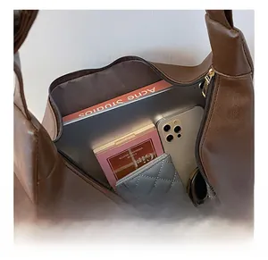 Detail view of large interior space showing laptop and daily essentials in brown tote bag