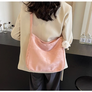 Pink PU leather hobo bag for women with a cute white plush monster charm on shoulder strap