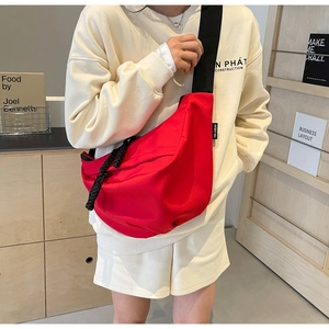 Detail of bright red nylon crescent crossbody bag with thick woven zipper puller