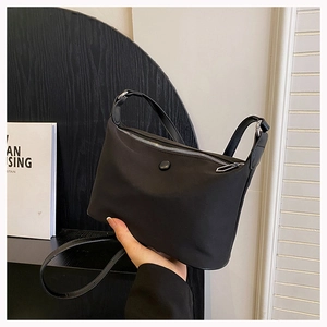 Chic black nylon crossbody bag with silver zipper and adjustable strap in a modern style