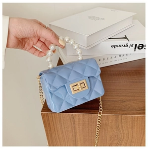 Gros plan du mini sac gelée bleu clair avec motif matelassé et détail de perles