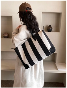 Grande borsa tote a righe bianche e nere con base in pelle e manici in materiale pregiato