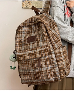 Vue détaillée du sac à dos écossais rétro avec un pendentif poupée en peluche verte