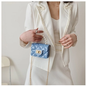 Détail du mini sac bleu clair avec poignée en perles et bandoulière chaîne dorée