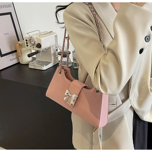 Dettaglio della borsa baguette rosa lucida con fibbia in metallo argentato a forma di fiocco
