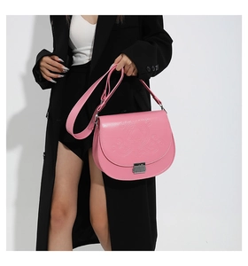 Détail du sac de selle en similicuir rose avec gaufrage en étoile et boucle argent