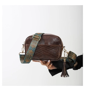 Detail of retro brown PU leather crossbody bag with V-shaped stitching and tassel