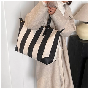 Dettaglio della borsa tote minimalista a righe bianche e nere con angoli in pelle