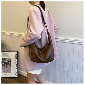 Detailed view of dark brown leather hobo bag with a soft texture and adjustable strap