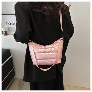 Pink metallic puffer bag detail showing glossy quilted texture and textile strap with metal clip