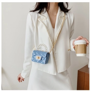 Gros plan du mini sac matelassé bleu clair avec anse en perles et bandoulière chaînette