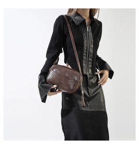 Detailed view of vintage dark brown crossbody bag with V-shaped quilting and fringe