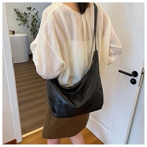 Lifestyle shot showing the fit and drape of the black large hobo bag on shoulder